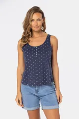 Musculosa azul con estampado de formas geométricas en blanco, escote redondo y botones decorativos en el frente.