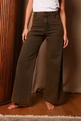 Jean wide leg color marrón oscuro con efecto oxidado, tiro alto y cierre de botón y cremallera.