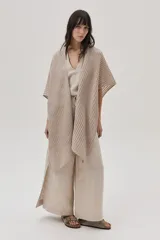Ruana beige de tejido de punto acanalado con mangas cortas.