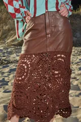 Falda midi de cuero marrón con detalle de crochet artesanal en el ruedo.