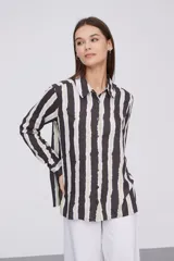 Camisa de manga larga con estampado a rayas verticales en tonos negro, blanco y verde claro.