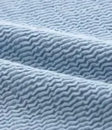 Remera celeste de algodón texturizado, corte boxy, cuello redondo y manga corta.