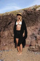 Triángulo de lana tejido a mano, color crudo, con flecos largos en todo el borde.