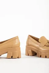 Mocasines negros de cuero con suela track y detalle de borlas.