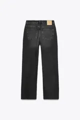 Pantalón de jean color crudo, de tiro alto, corte recto y largo tobillero. Tiene cinco bolsillos, cierre frontal con cremallera y botón metálico.