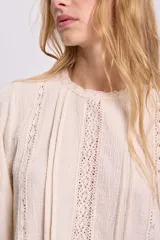 Blusa color crudo de manga larga con detalles de puntilla.