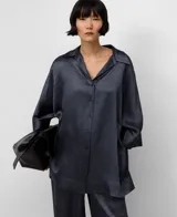 Camisa oversize de mujer, color gris oscuro, confeccionada en acetato 100% con efecto arrugado y brillo natural. Presenta cuello italiano y manga japonesa con puño ancho.
