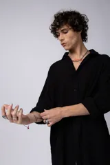 Camisa blanca de lino con cuello clásico, manga larga con puños abotonados y corte holgado. 