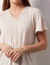 Remera verde con escote en V y apliques de crochet en el cuello y en el centro.