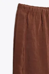 Pantalón de tiro medio color marrón, confeccionado en hilatura con mezcla de lyocell, cintura elástica ajustable con cordones y pierna ancha.