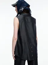 Camisa sin mangas en denim color celeste, confeccionada en 100% lyocell. De corte recto y largo medio, presenta cartera escondida en el frente y un bolsillo plaqué en el pecho. En la espalda, tiene botones decorativos alineados en abertura vertical y pespuntes a contratono.