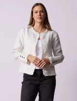Chaqueta cruda de tejido boucle con flecos en el borde y botones negros en los puños.