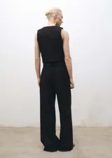 Chaleco negro de vestir con cuello de pico y cierre frontal con botones.