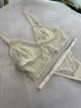 Conjunto de encaje color crema con top de estilo bralette y tanga colaless regulable, confeccionado en tela suave y elastizada.