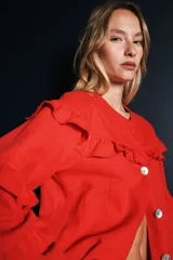 Campera de jean gris oscuro con volados en el frente y las mangas, de corte recto y largo a la cadera.