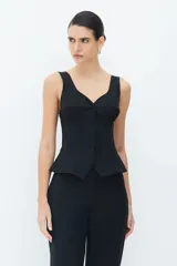 Blusa de algodón color blanco roto con tirantes anchos y corte en el busto, elástico en los tirantes para ajustar, bajo ancho y cierre con botones forrados.