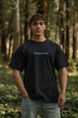 Remera negra de manga corta raglán, confeccionada en algodón. Presenta costuras a la vista y calce relajado.