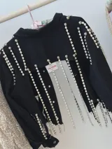 Campera cropped de jean negra con tiras de strass plateado y botones plateados al frente.