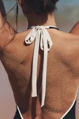 Bañador negro con escote pronunciado en V, cuello halter con lazo blanco y forro interior.