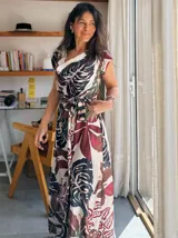 Vestido largo con estampado de hojas en tonos marrones, amarillos y verdes. Tiene escote cruzado y cinturón de la misma tela.