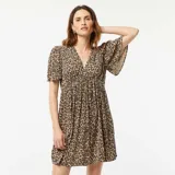 Vestido corto de punto crepé color beige con estampado animal print, escote en V y mangas cortas.