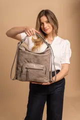 Cartera mochila color tostado, símil cuero, con compartimiento principal amplio y bolsillos frontales con cierre. Tiene correas ajustables para usar como mochila y asa superior para llevar al hombro.