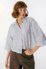 Camisa celeste a rayas verticales blancas con bordado de flores blancas, de corte recto y mangas 3/4.