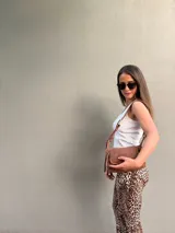 Cartera bandolera de cuero color marrón, con correa ajustable y bolsillo externo con cierre.