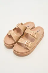 Sandalias bajas color beige con doble tira con hebilla y detalle de costuras en los bordes.