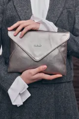 Clutch plateado de cuero metalizado con diseño tipo sobre, cierre de solapa con imán y asa de cadeneta metálica.