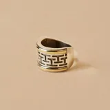 Anillo ancho de plata y oro con diseño de laberinto griego.