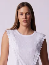 Blusa blanca texturizada de la marca Marissa Olivia. Presenta apliques de crochet en la parte delantera y un detalle fruncido en el ruedo.
