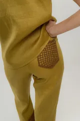 Pantalón de lino color ocre, de tiro medio y pierna recta. Cuenta con detalle de crochet tejido a mano en la pierna baja.