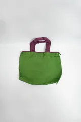 Bolso tipo tote bag verde con asas cortas color borgoña y cierre superior con cremallera.