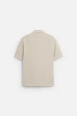 Camisa celeste de corte recto, manga corta y cuello solapa.