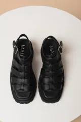 Sandalias de tiras anchas color blanco, con plataforma track negra y hebilla lateral ajustable.