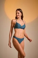 Top de bikini color marfil con textura acanalada, escote halter con aros dorados y cierre posterior con broche.