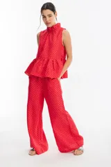 Pantalón de lino rojo con print plateado, con cintura elástica, bolsillos laterales y piernas anchas.