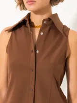 Camisa sin mangas confeccionada en tela de punto lisa, color negro, de corte regular. Lleva cartera con broches JCH y pinzas que entallan la prenda.