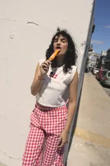 Pantalón midi con estampado de cuadrillé rojo y blanco, con aberturas laterales que se ajustan con lazos.
