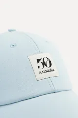 Gorra rosa de algodón con visera y parche bordado con el número 50 y la leyenda "A Coruña".