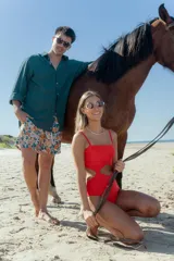 Traje de baño enterizo color naranja con breteles finos y abertura en la zona del abdomen.