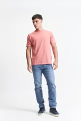 Remera color salmón de corte clásico, cuello redondo y logo bordado en el pecho.