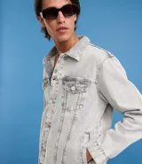 Campera de jean de hombre, modelo regular, con efecto desteñido en tonos grises claros. Presenta cuello inglés, manga larga, abotonado frontal y dos bolsillos con solapa y botón en el pecho.