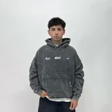 Buzo hoodie gris con efecto lavado, corte boxy y estampado frontal con el logo de la marca.