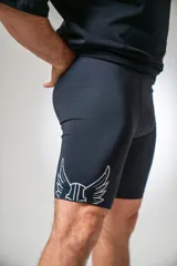 Calza corta deportiva negra con estampado de alas blancas en el muslo.