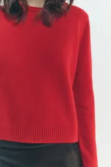 Jersey rojo de punto liso confeccionado en 100% lana. Tiene cuello redondo, manga larga y acabados en rib.