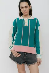 Sweater de punto color verde esmeralda, con cuello polo, mangas largas color crema y detalles en rosa.