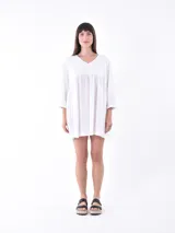 Vestido corto blanco con escote en V y mangas 3/4.