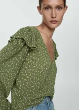 Blusa de manga larga con estampado floral en tonos rosa y blanco, escote en V, volantes en los hombros y puños elásticos.